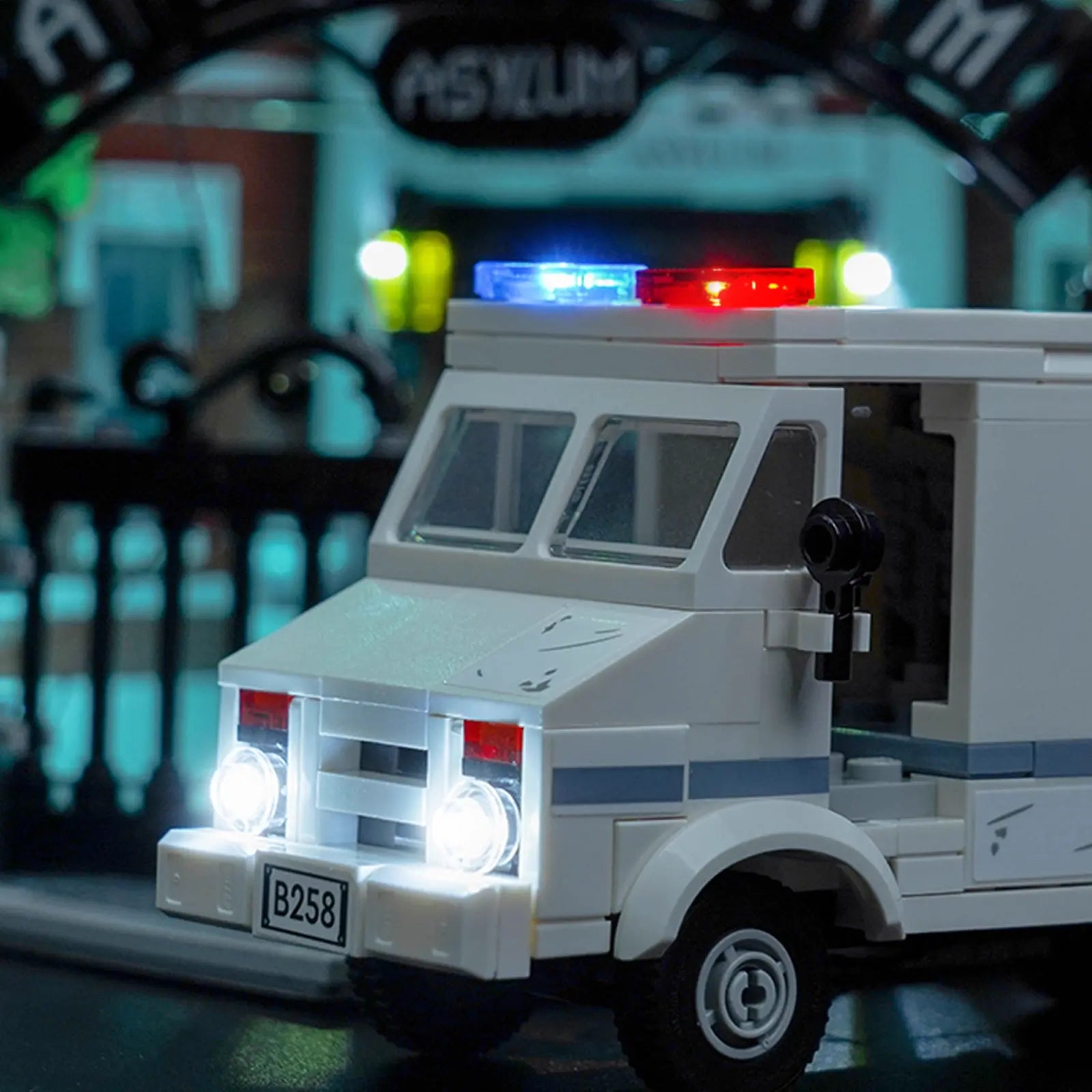 A side profile of the LEGO Arkham Asylum, showing light spilling from multiple floors and highlighting the building's depth.