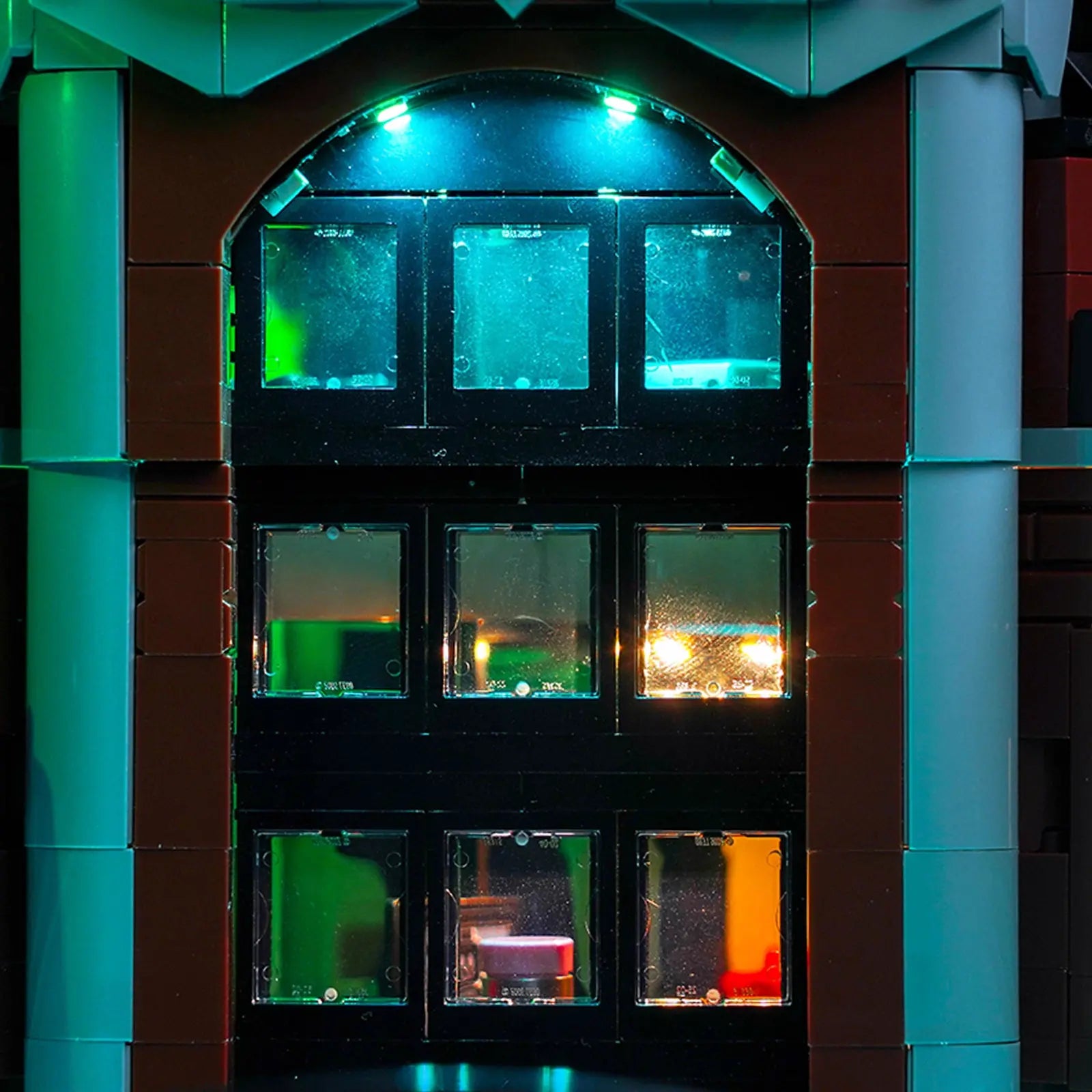 A sinister red and green glow emanates from the inmate cells of the LEGO Arkham Asylum, creating a truly spooky effect.