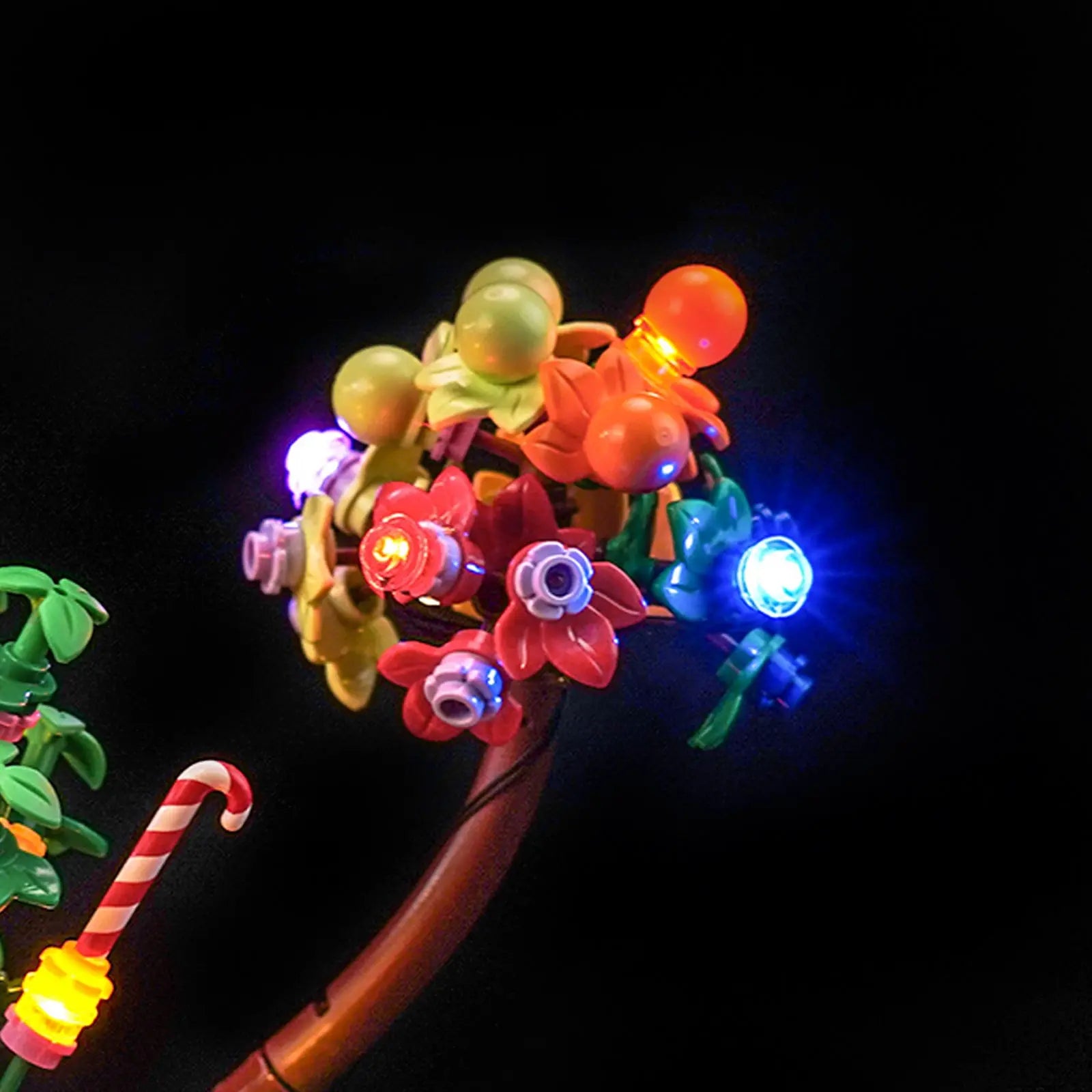 Willy Wonka, Charlie, and the other minifigures are highlighted under the magical lights of the Chocolate Room display.