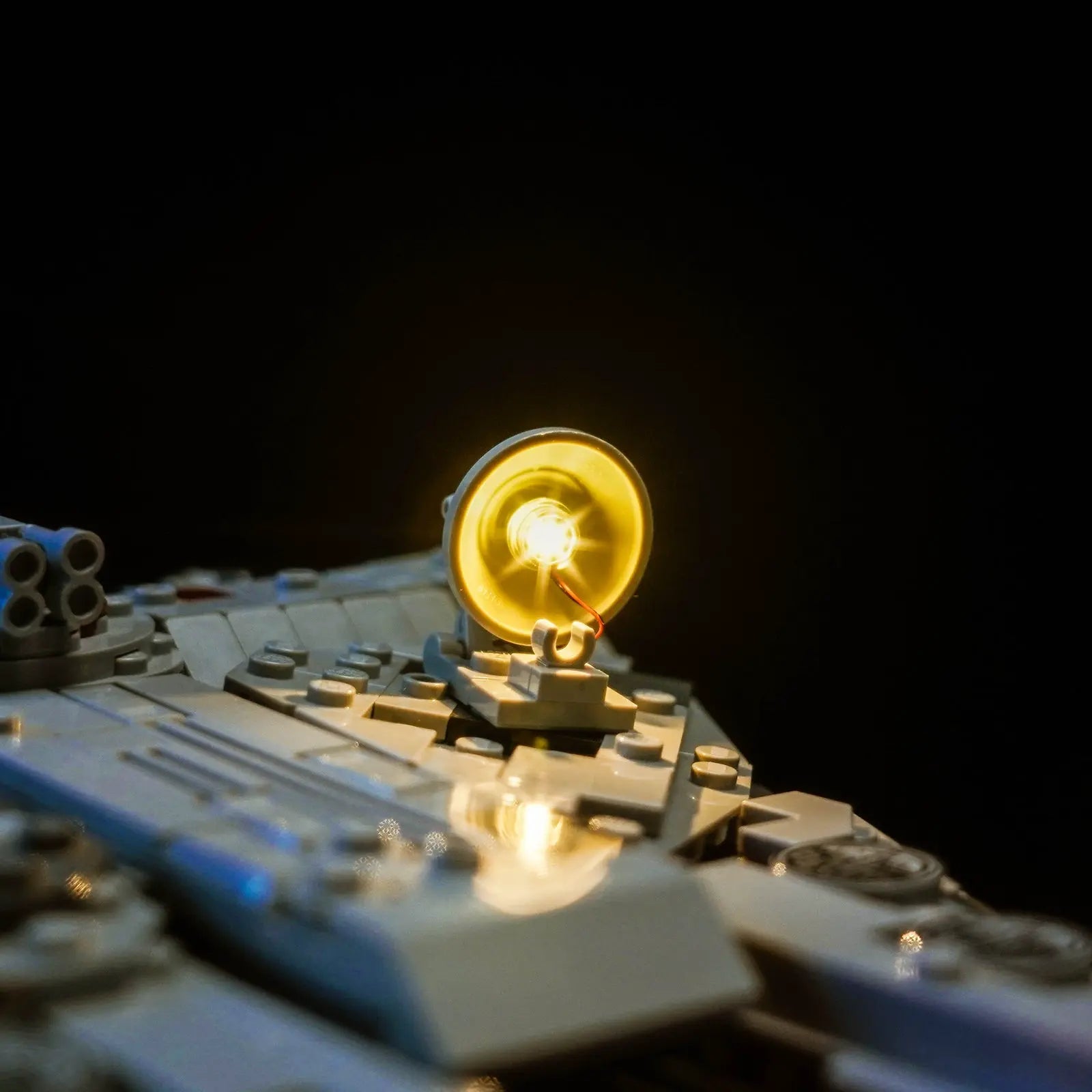 A dynamic, cinematic shot of the lit-up LEGO Star Wars Millennium Falcon 75375 as if it's banking in flight.