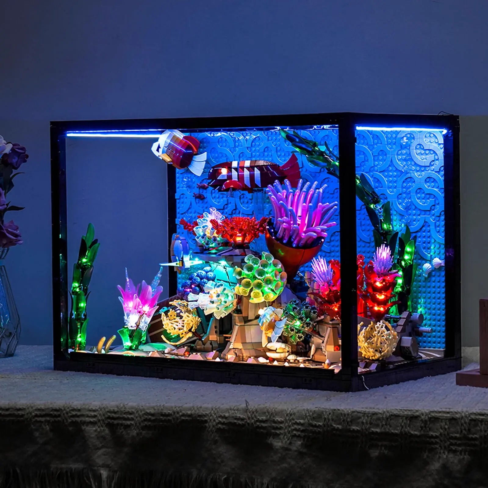 A close-up of the colorful LEGO tropical fish, glowing vividly under the custom lighting of our aquarium kit.