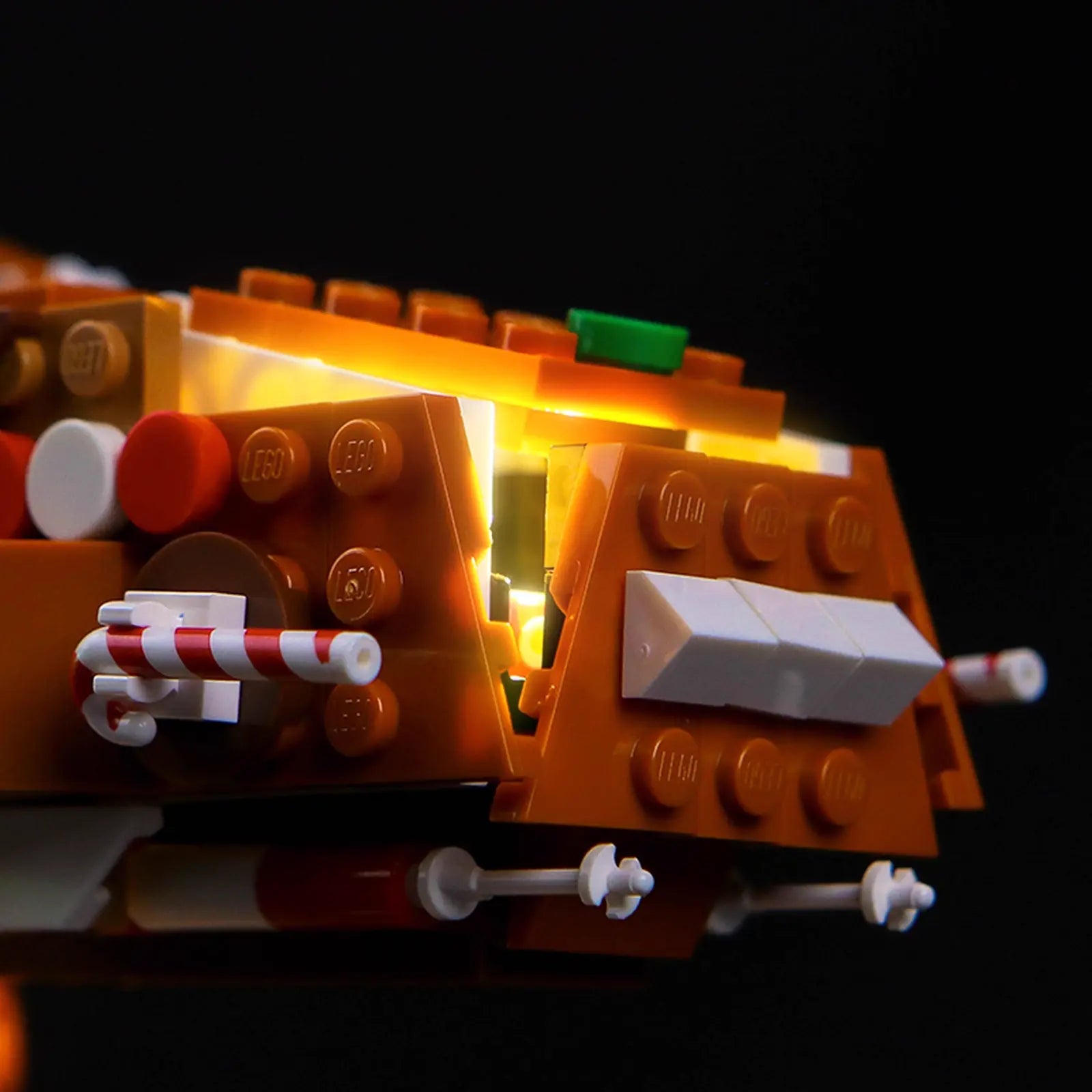 The illuminated LEGO Gingerbread AT-AT 40806 is shown as part of a larger, festive holiday decoration scene.