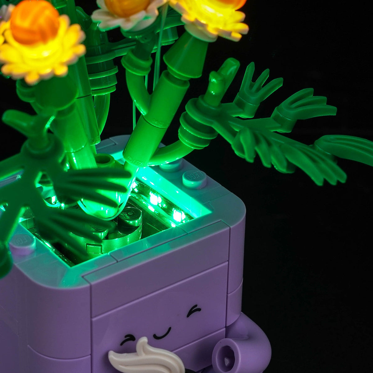 Side detail of the purple pot with green-lit foliage and yellow flowers — LEGO® Cozy Plants #10371