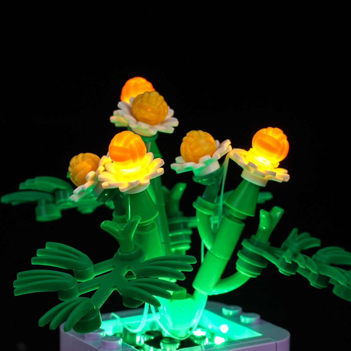 Close-up of yellow-lit flowers above the purple pot — LEGO® Cozy Plants #10371