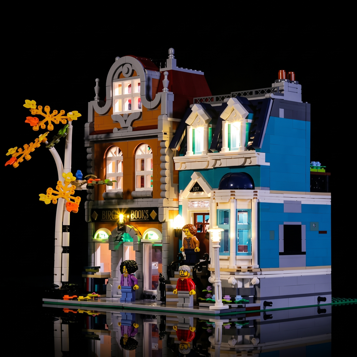 Rechte Vorderansicht der beleuchteten LEGO Buchhandlung 10270 mit Erker und oberen Fenstern