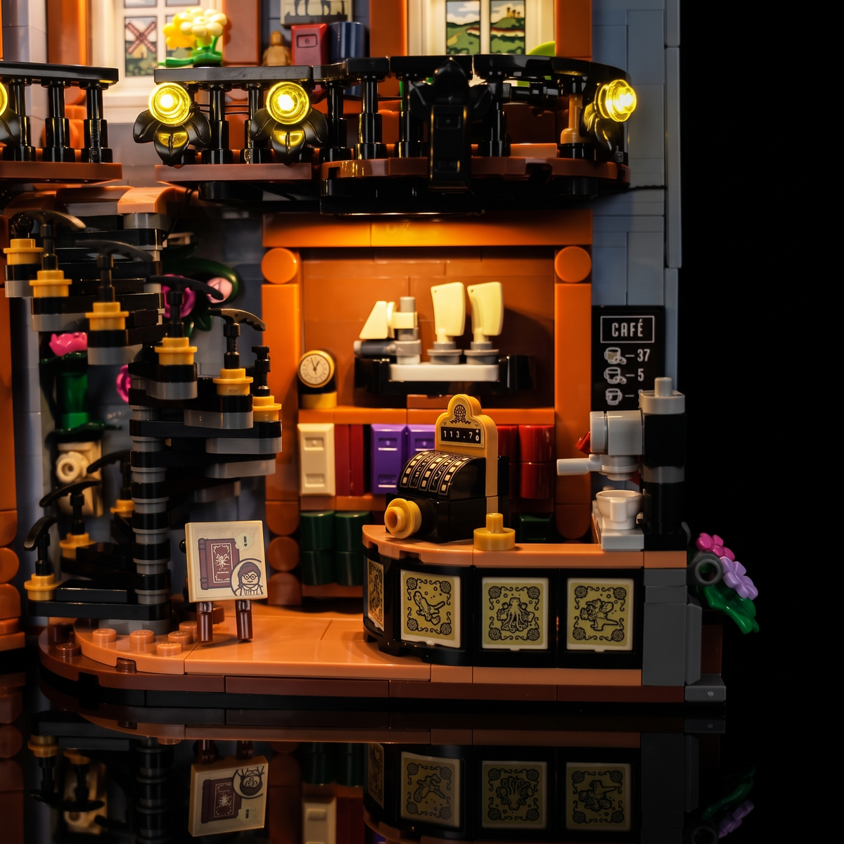 Gros plan sur le comptoir du café et l’escalier en colimaçon illuminés du LEGO® La librairie : book nook #11379