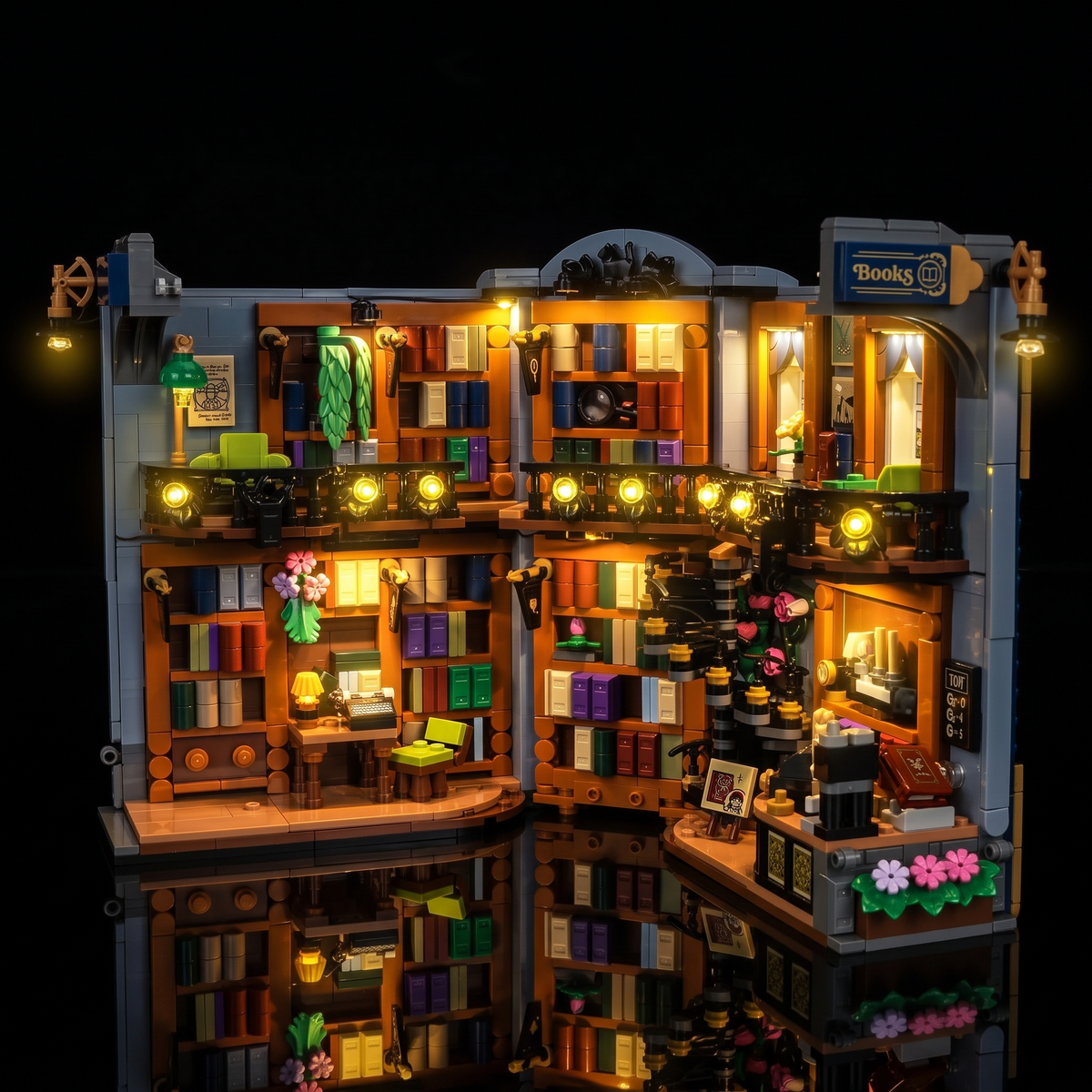 Vue de face du LEGO® La librairie : book nook #11379 ouvert avec éclairage chaud des étagères, fenêtres et café