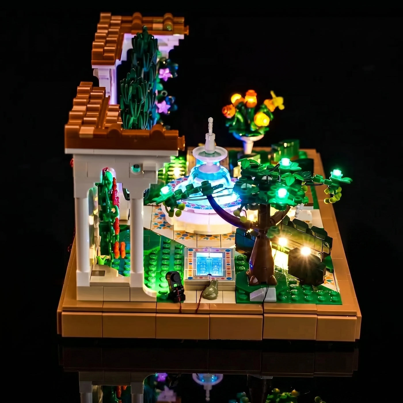 LEGO® Icons Fountain Garden #10359 fully illuminated on display, with the LED lights