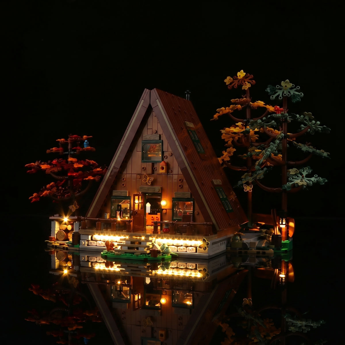 LEGO® Ideas A-Frame Cabin #21338 fully illuminated on display, with the LED lighting kit