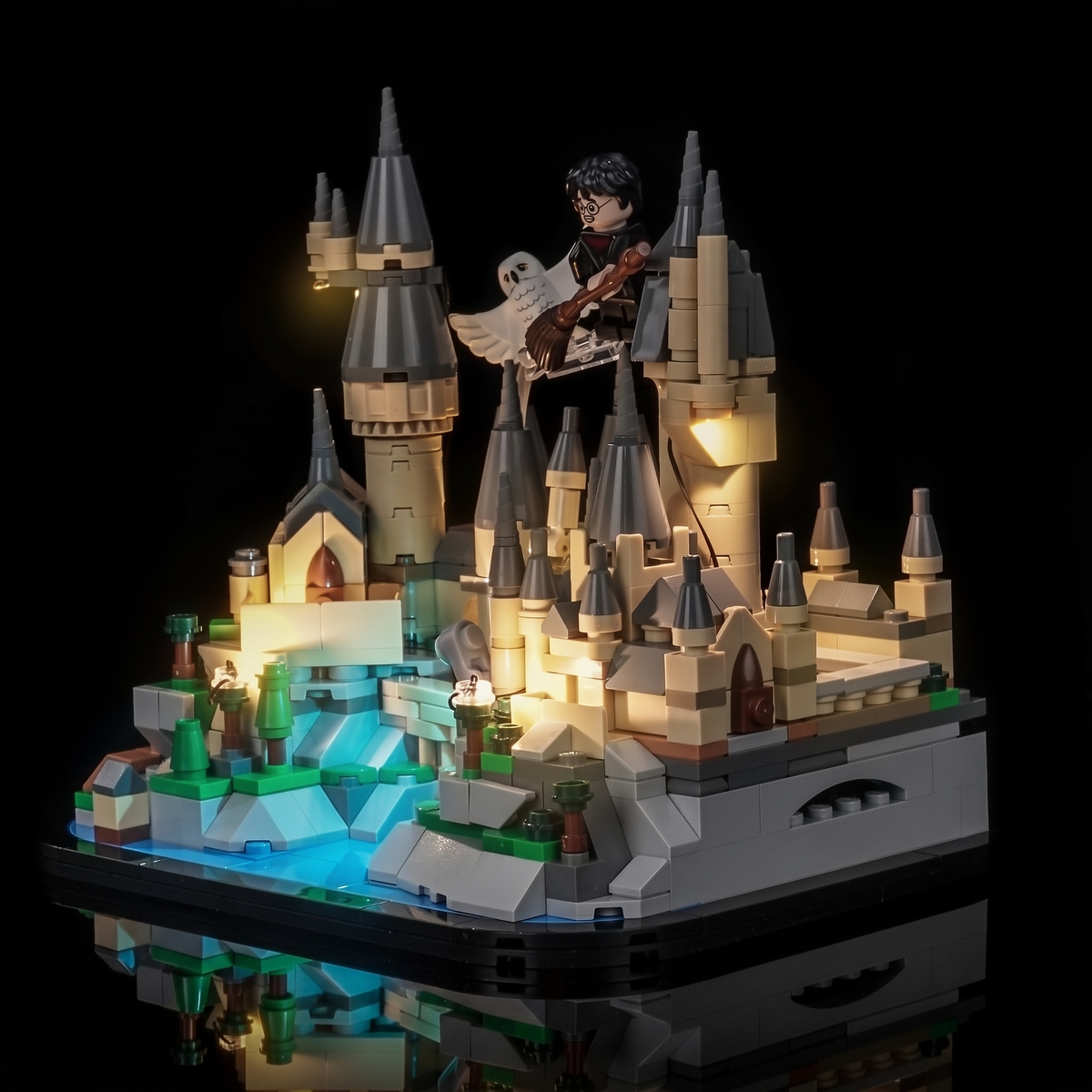Dreiviertelansicht von LEGO Mini-Schloss Hogwarts 40975 mit warmem LED-Licht und blauem Schein am See