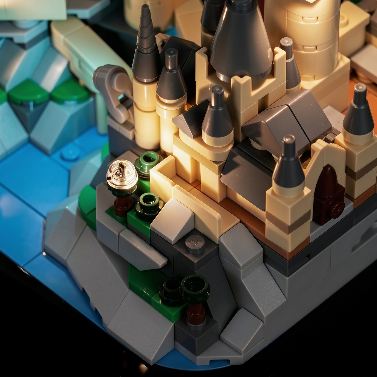 Detailansicht von oben auf den warm beleuchteten Hof und die spitzen Türme von LEGO Mini-Schloss Hogwarts 40975