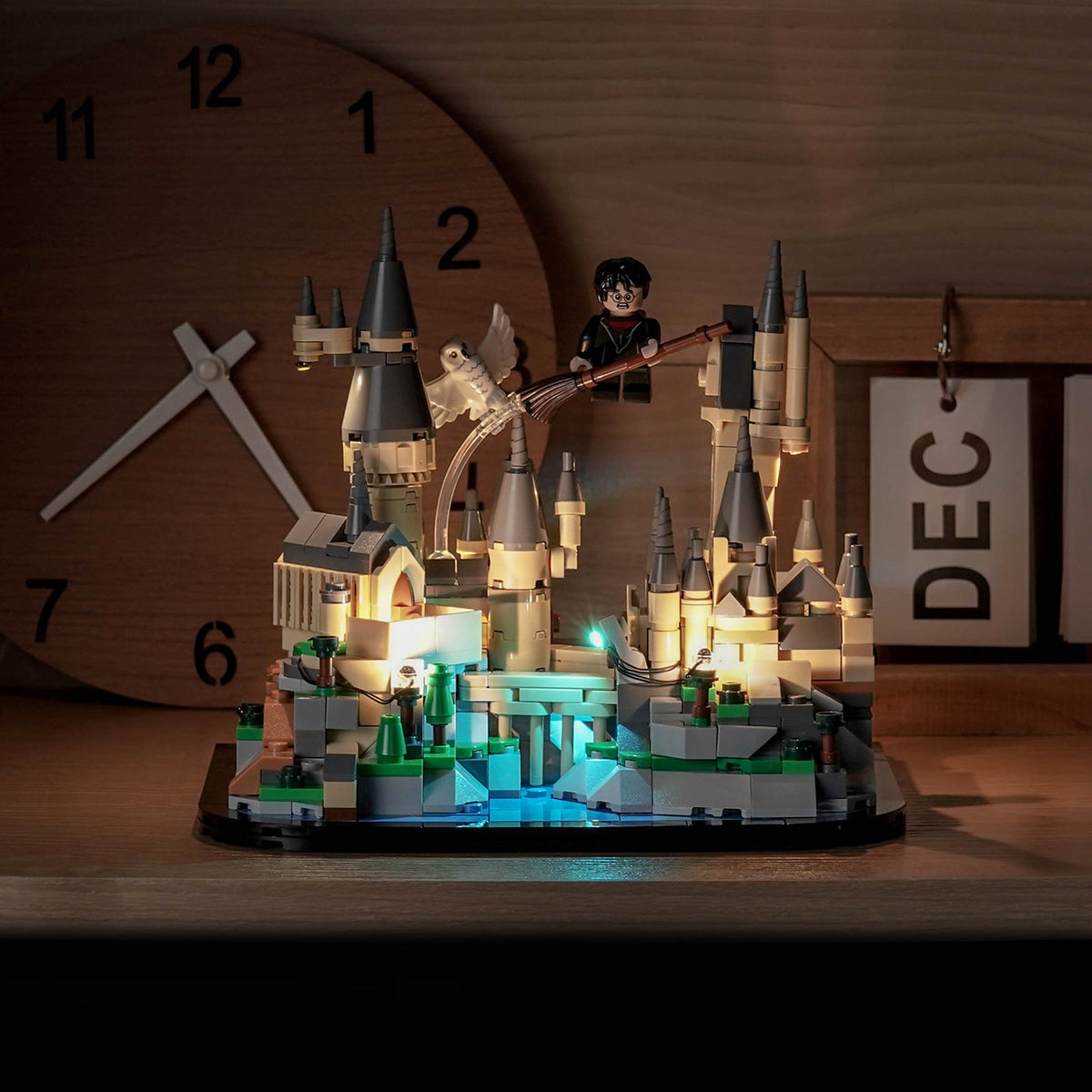 LEGO Mini-Schloss Hogwarts 40975 mit LED-Kit neben einer Uhr, warm beleuchteten Türmen und cyanblauem See