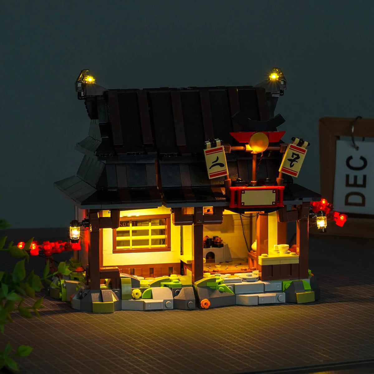 LEGO® Ninjago Four Weapons Blacksmith 15th Anniversary #71858 front view fully lit, with the LED light kit