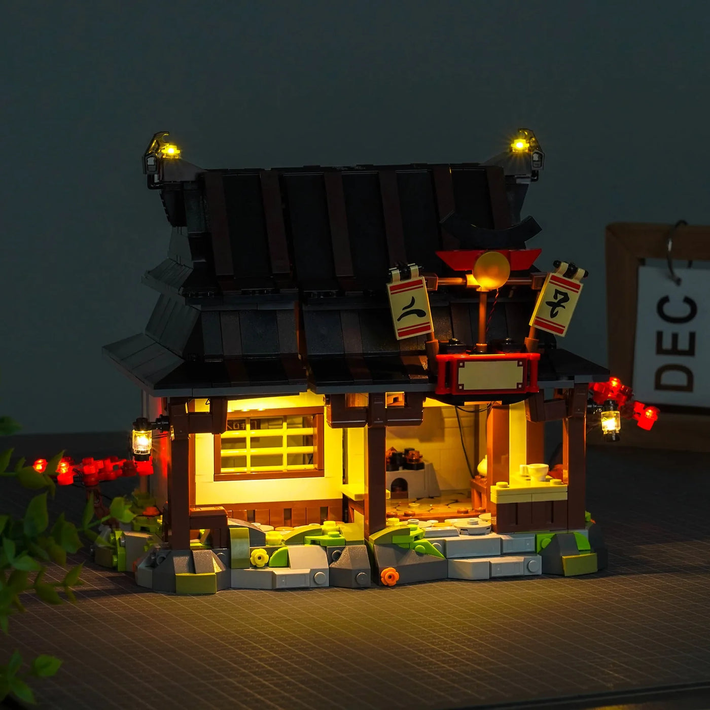 LEGO® Ninjago Four Weapons Blacksmith 15th Anniversary #71858 front view fully lit, with the LED light kit