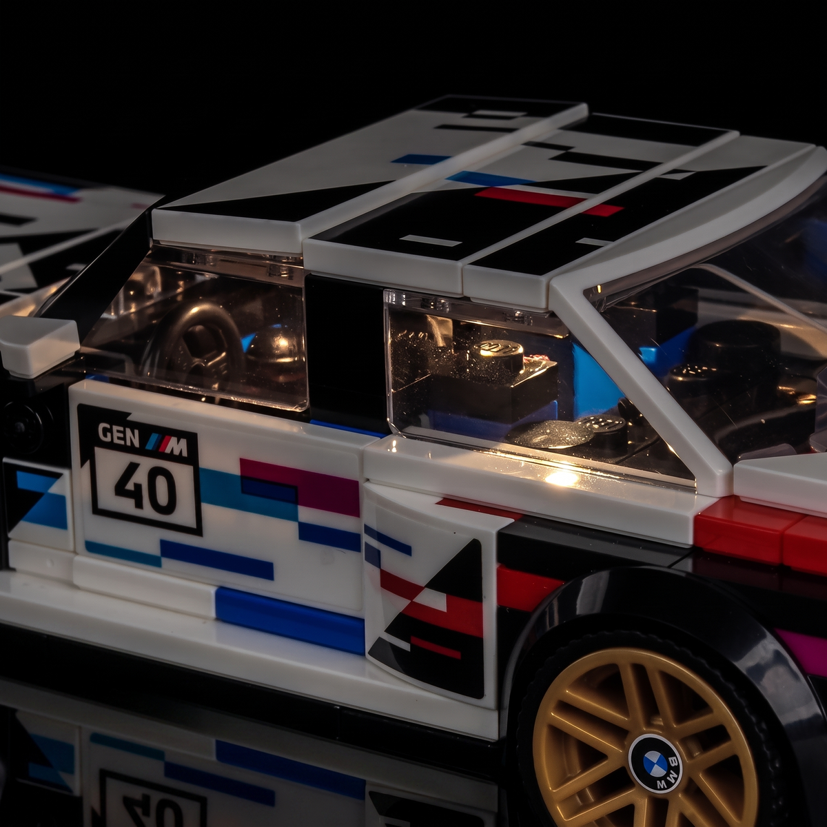 LEGO® Speed Champions BMW M3 (E30) #77263 seen from the rear, tail lamps on, with the USB-powered LED light kit