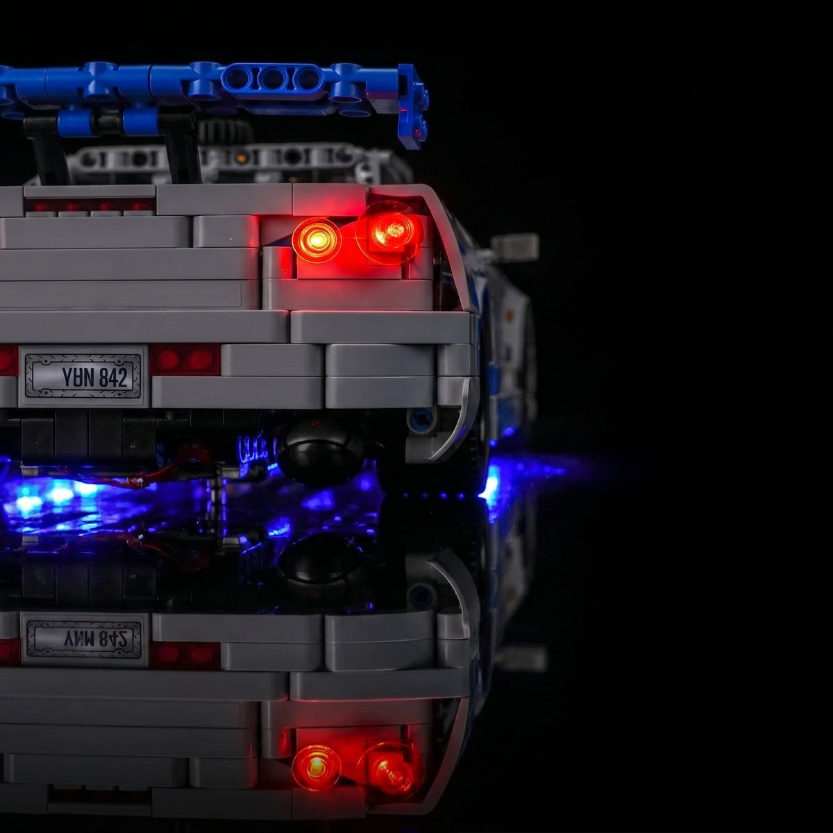 LEGO® Technic 2 Fast 2 Furious Nissan Skyline GT-R (R34) #42210 fully illuminated on display, with the custom LED lighting