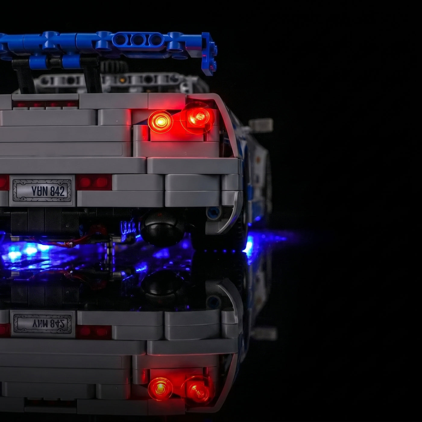 LEGO® Technic 2 Fast 2 Furious Nissan Skyline GT-R (R34) #42210 fully illuminated on display, with the custom LED lighting