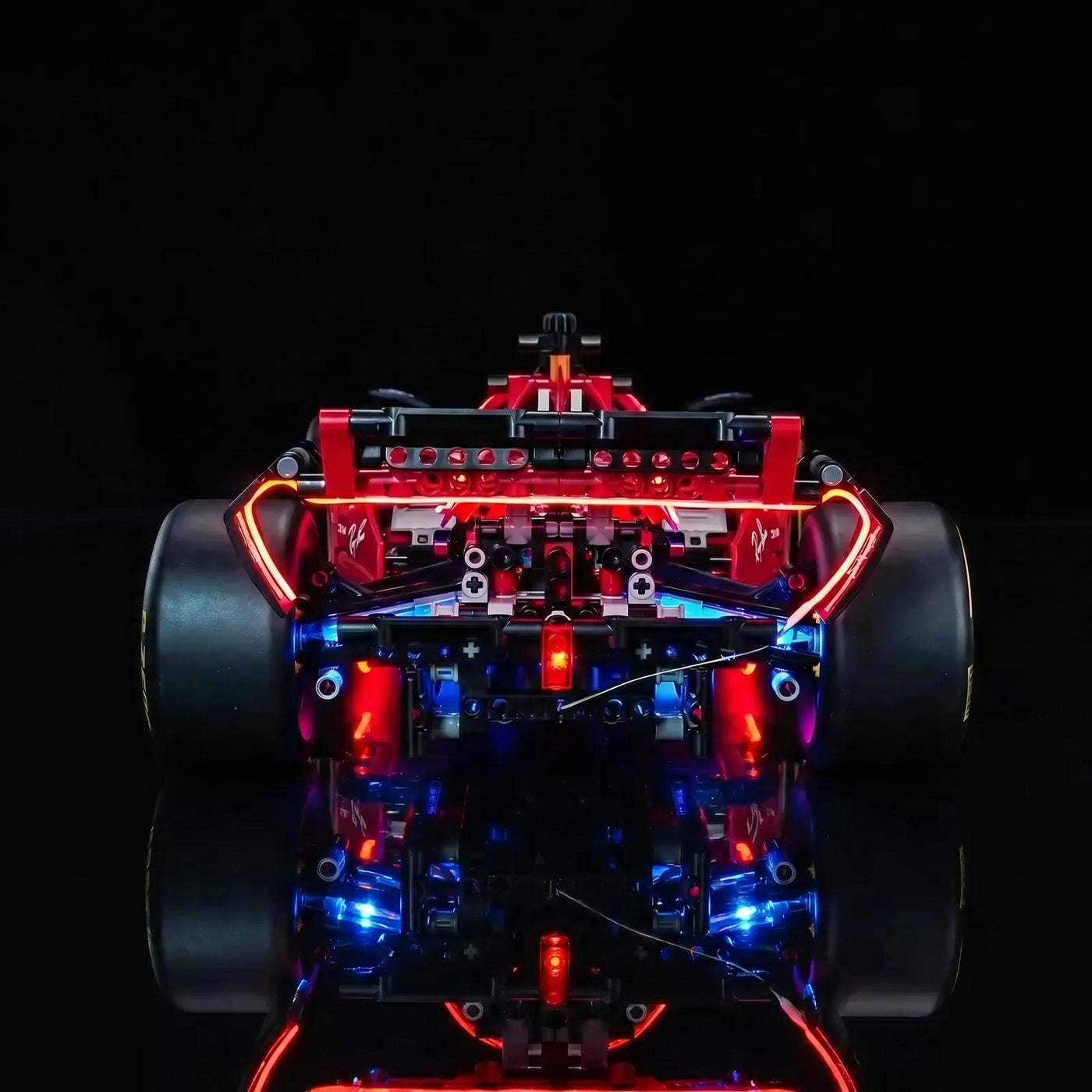 LEGO® Technic Ferrari SF-24 F1 Car #42207 fully illuminated on display, with the display light kit