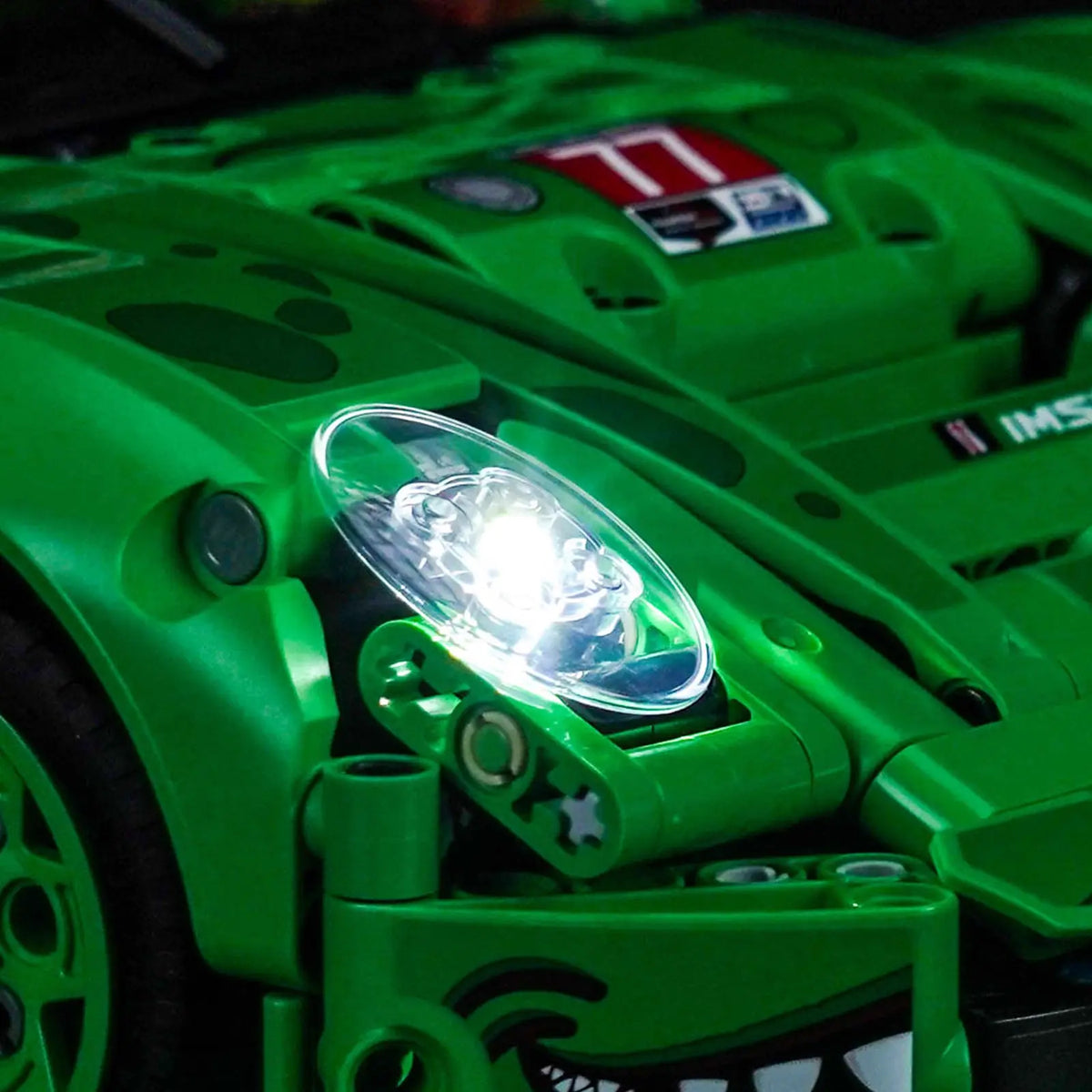 LEGO® Technic Porsche 911 GT3 R REXY AO Racing Car #42224 fully illuminated on display, with the LED lights