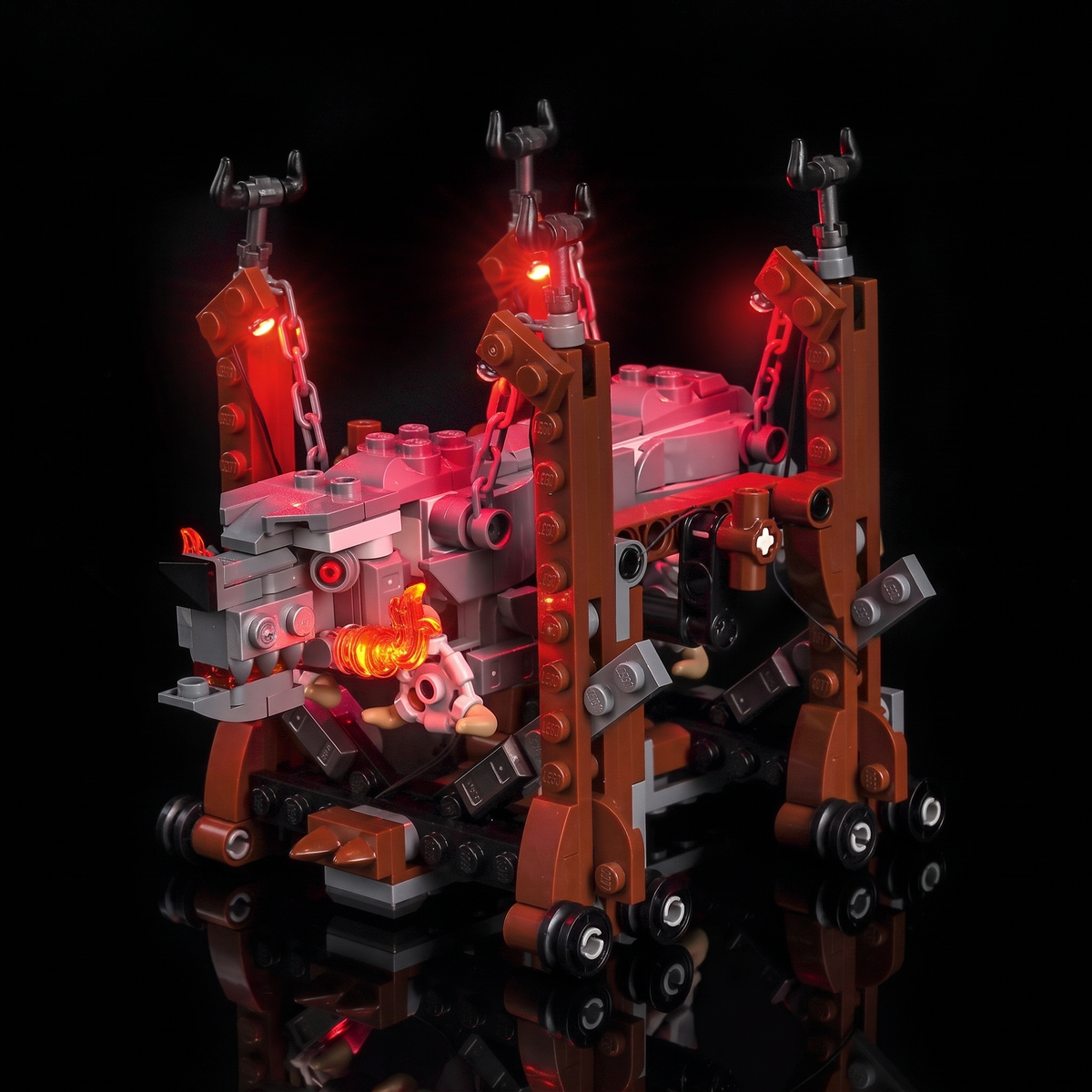 Full front three-quarter view showing the lit ram, frame, wheels and orange fangs — LEGO® Grond #40893, LED light kit