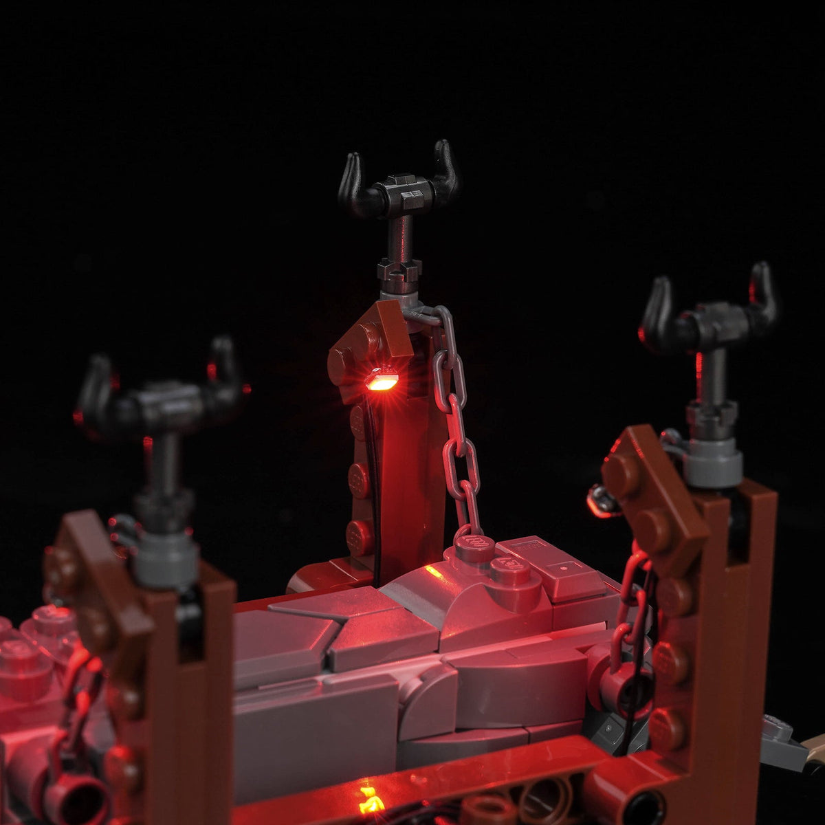Side close-up showing red light along the grey ram and timber supports — LEGO® Grond #40893, LED light kit
