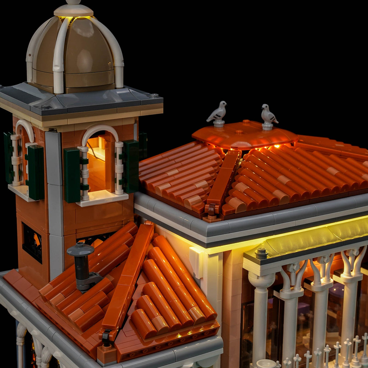 Gros plan du clocher éclairé et de la ligne lumineuse au-dessus des tuiles rouges — LEGO® Le quartier vénitien #11388