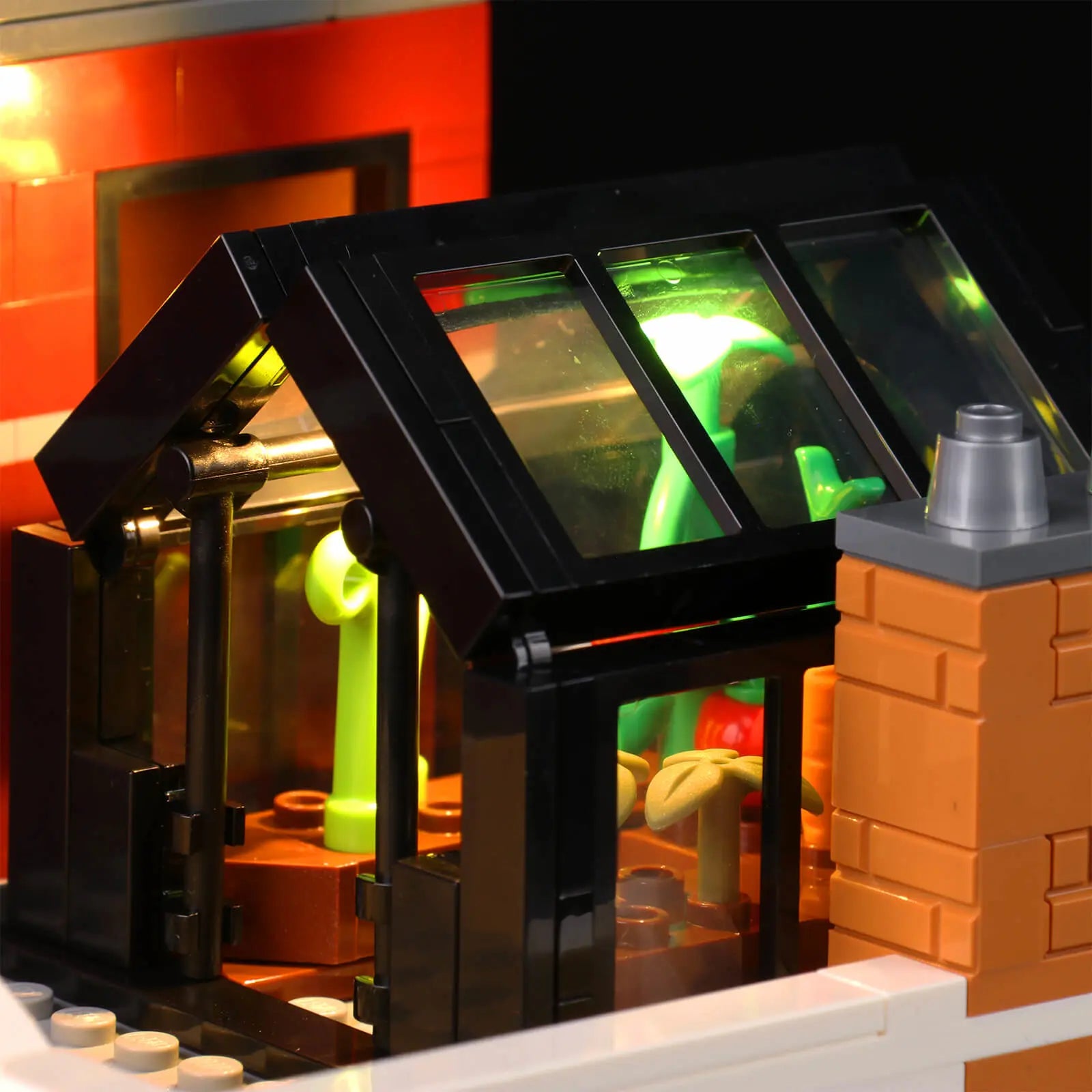 The rooftop greenhouse of the LEGO Jazz Club 10312 is softly lit by a Bright My Bricks display lights kit for a nighttime ambiance.
