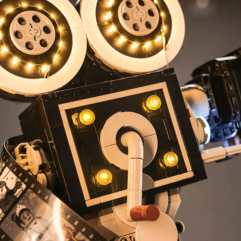 A side profile of the LEGO 43230 camera, showing the warm interior light and the glowing film strip.